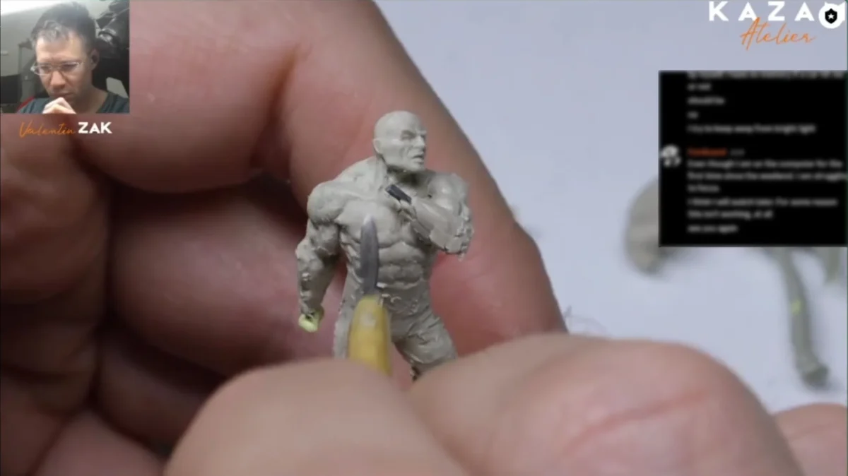Toy hand sculpture with a printed man’s face and text 'KAZAO Virtin. ZAK'